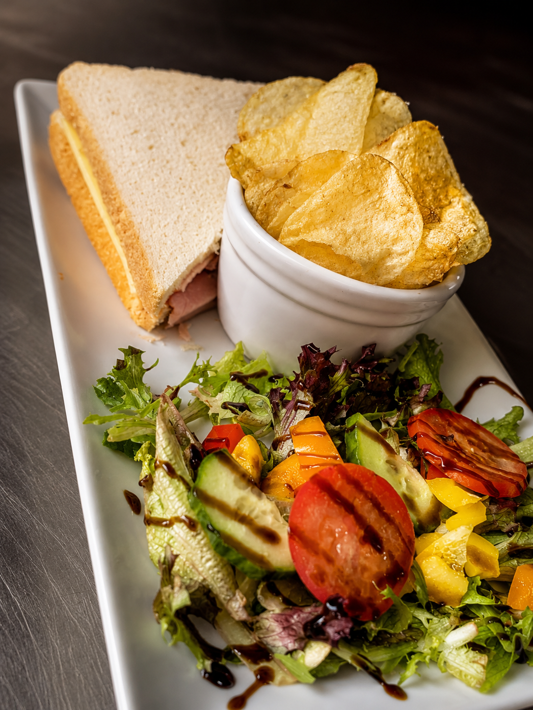 A toasted sandwich with crisps and side salad